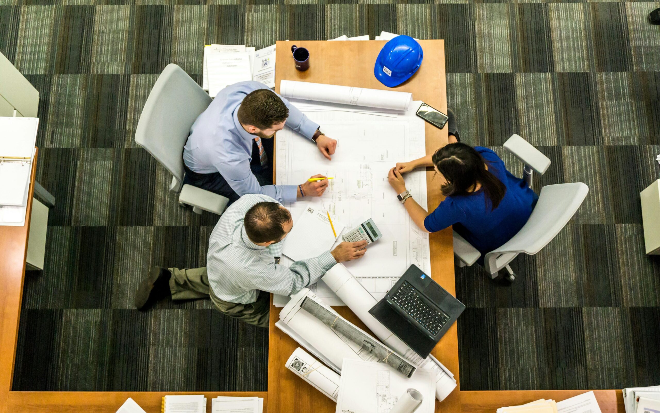 Construction company executives reviewing plans and calculating costs. The extensiveness of the construction plan requires fast construction loans to ensure timely funding and project execution.